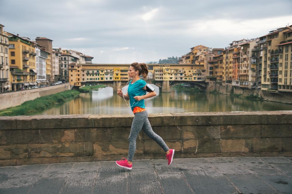 Young,Female,Jogger,With,Headset,Is,Running,By,Arno,Riverside